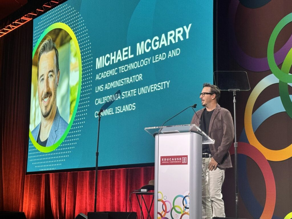 Michael McGarry on the main stage at EDUCAUSE, speaking to the audience.
